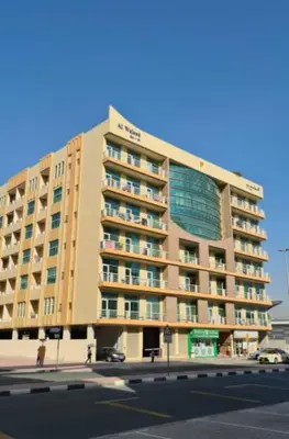 a large apartment building on the corner of a street at Decent Room with Balcony Near Mall of the Emirates in Dubai