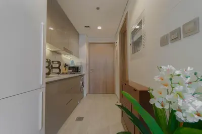 a hallway of a kitchen with a door and flowers at Creek view studio deleguest in Dubai
