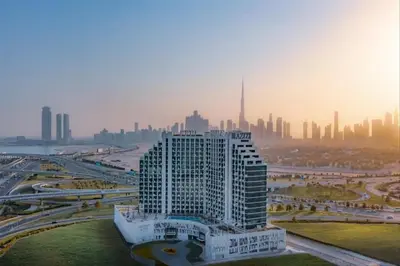 a tall white building with a city in the background at Creek view studio deleguest in Dubai