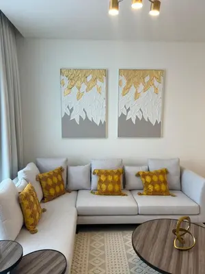 a living room with a white couch with yellow pillows at 2 Bedrooms - District One Residences 13 in Dubai