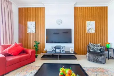 a living room with a red couch and a tv at An Elegant Fully Furnished 1 Bedroom Apartment in Clayton Residency, Business Bay, Dubai in Dubai