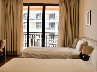 a hotel room with two beds and a balcony at Waterfront 2BR Apartment with Sea Views in Dubai