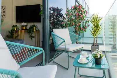 a patio with two chairs and a table with a tv at Studio next Dubai Mall with pool in Dubai