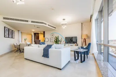 a living room with a white couch and a table at Elegant 2BR in Sky Gardens DIFC by Deluxe Holiday Homes in Dubai