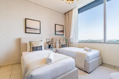 two beds in a room with a large window at Elegant 2BR in Sky Gardens DIFC by Deluxe Holiday Homes in Dubai