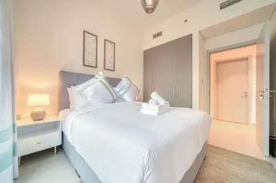 a white bedroom with a large white bed and a nightstand at Forte 2, Downtown Dubai - Mint Stay in Dubai