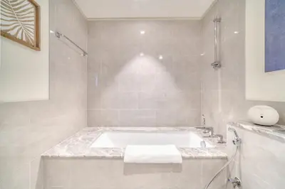 a white bathroom with a tub and a sink at Forte 2, Downtown Dubai - Mint Stay in Dubai
