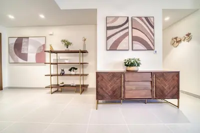 a living room with a dresser and paintings at Forte 2, Downtown Dubai - Mint Stay in Dubai
