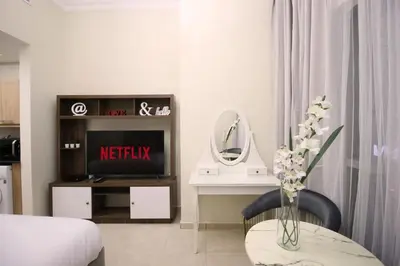 a living room with a bed and a vase of flowers at Studio in Dubai Marina by beach & Metro - Z313 in Dubai
