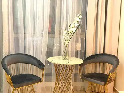 two chairs and a table with a vase of flowers at Studio in Dubai Marina by beach & Metro - Z313 in Dubai