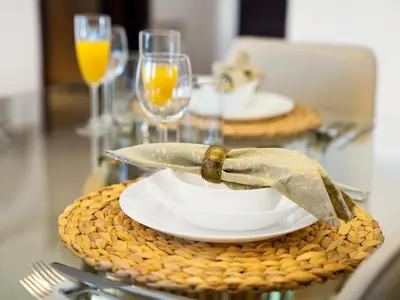 a table with a plate with a knife and a napkin at Kensington Stylish 1BR at The Lofts East Downtown in Dubai