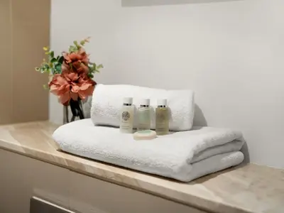 a pile of towels on a counter in a bathroom at Kensington Stylish 1BR at The Lofts East Downtown in Dubai