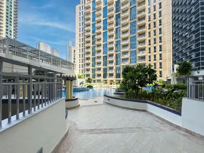 a balcony with a pool in a city with tall buildings at Kensington Chic 1BR Fountain-view Flat Downtown Burj Khalifa in Dubai