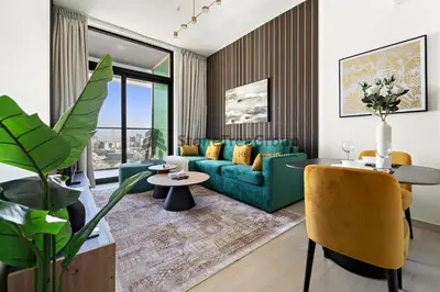 a living room with a blue couch and yellow chairs at High-Floor and Spacious 1BR at Binghatti Emerald in Dubai