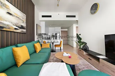 a living room with a green couch and a table at High-Floor and Spacious 1BR at Binghatti Emerald in Dubai
