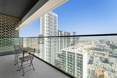 a balcony with a table and chairs in a building at High-Floor and Spacious 1BR at Binghatti Emerald in Dubai