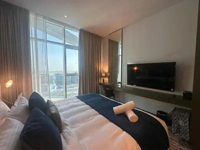 a hotel room with a large bed with a large window at Business Bay Modern studio with a Pool view at DAMAC Maison Prive in Dubai