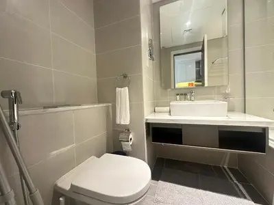 a bathroom with a white toilet and a sink at Business Bay Modern studio with a Pool view at DAMAC Maison Prive in Dubai