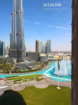 a view of a city with tall buildings and a fountain at Luxury Apartment with Burj Khalifa View, Balcony Netflix WeHome Premium in Dubai