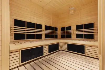 a sauna with wood paneled walls and a wooden floor at Luxury Apartment with Burj Khalifa View, Balcony Netflix WeHome Premium in Dubai