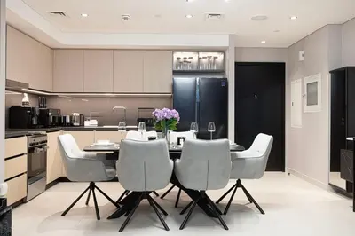 a kitchen with a table with chairs and a refrigerator at Luxury 4BR Burj Khalifa View Dubai Mall in Dubai