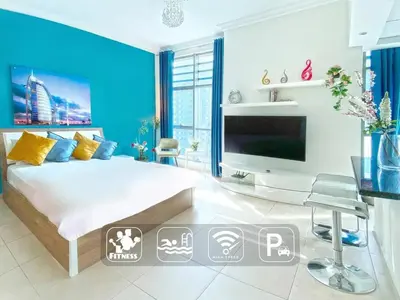 a bedroom with a large bed and a large television at Cozy Studio at Marina near Beach and Metro in Marina Z817 in Dubai