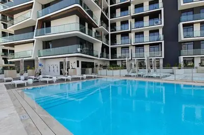 a large swimming pool in front of a building at Locations I Binghatti Luna - JVC I Modern 1BR Apartment I Upgraded Interiors & Comfortable Stay I Scenic Community & Skyline Views in Dubai