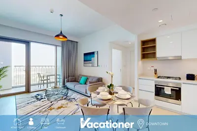 a kitchen and living room with a table and chairs at Vacationer l High Rise 1 Bedroom l Close to Dubai Mall l Pool Access with Burj Khalifa Views in Dubai