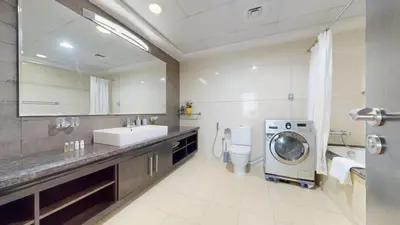 a bathroom with a sink and a washing machine at Vacationer I Lux 3 Bedroom Apartment I Steps from Barasti Beach in Dubai