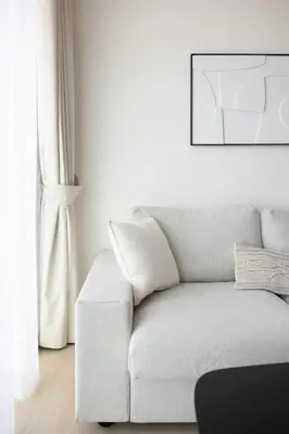a white living room with a couch and a picture at Bright 1BR with balcony in Binghatti Corner in Dubai
