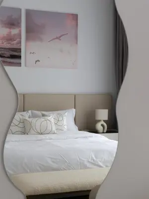a bedroom with a white bed with a painting on the wall at La Vie JBR Beatiful 1 Bed Seafront in Dubai