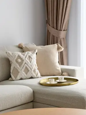 a couch with a gold tray and two cups on it at La Vie JBR Beatiful 1 Bed Seafront in Dubai