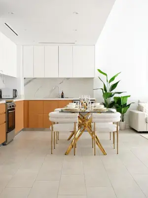 a kitchen with a table and white cabinets at La Vie JBR Beatiful 1 Bed Seafront in Dubai