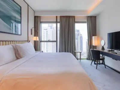 a hotel room with a large white bed and a desk at Beach Rental- Grand Creek Harbour in Dubai in Dubai