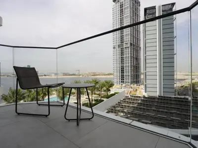 a chair and a table on a balcony with a view at Beach Rental- Grand Creek Harbour in Dubai in Dubai