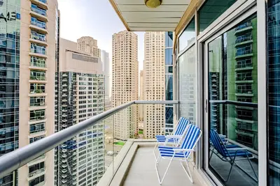 two chairs on a balcony with a view of the city at Breathtaking 1BDR Apartment in Dubai Marina I Bonair I Park Islands in Dubai