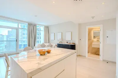 a kitchen with a large counter top and a living room at Breathtaking 1BDR Apartment in Dubai Marina I Bonair I Park Islands in Dubai
