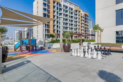 a chess game in a courtyard with a large building at GLOBALSTAY Azizi Riviera 48 in Dubai