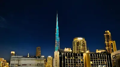 a tall tower in a city at night at Wohnung mit Blick auf den Burj Khalifa im Stadtzentrum von Dubai in Dubai