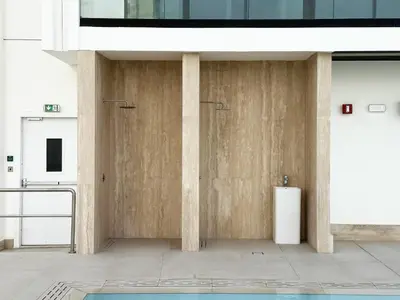 a bathroom with a wooden wall with a pillar at Trophy Luxury Stellar Sky Suites in JVC with Great Views in Dubai