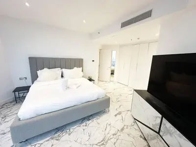 a bedroom with a bed and a flat screen tv at Modern & Bright Canal View 2BR Near Dubai Mall by Vibel in Dubai