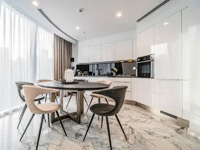 a kitchen and dining room with a table and chairs at Modern & Bright Canal View 2BR Near Dubai Mall by Vibel in Dubai