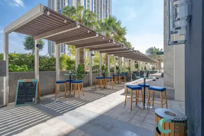 a row of tables and chairs under awnings on a patio at Cloud 9 - Luxurious 1 Bedroom Apartment in Business Bay in Dubai