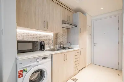 a kitchen with a washing machine and a sink at Charming Studio in Seven Palm with Balcony Rooftop Floor in Dubai
