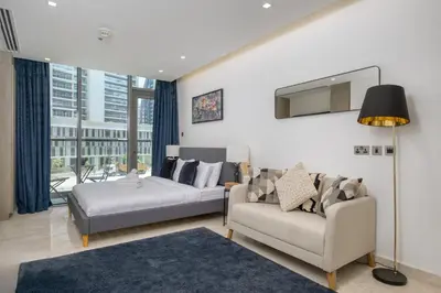 a living room with a couch and a chair and a tv at Downtown Apartment Studio near Burj Khalifa in Dubai