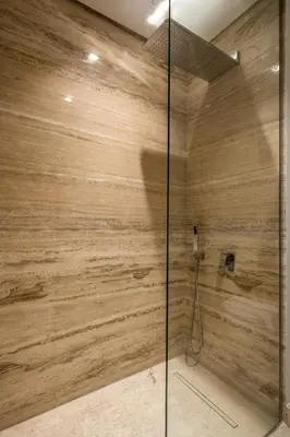a shower with wooden walls and a glass door at Downtown Apartment Studio near Burj Khalifa in Dubai