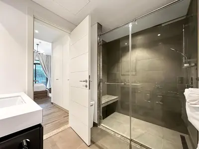 a bathroom with a glass shower and a sink at Super Spacious 2BR with Designer Touch in Dubai