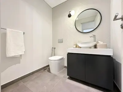a bathroom with a sink and a toilet and a mirror at Super Spacious 2BR with Designer Touch in Dubai