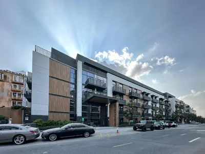 a parking lot with cars parked in front of a building at Super Spacious 2BR with Designer Touch in Dubai