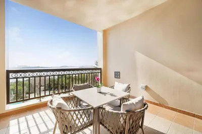 a dining room with a table and chairs and a large window at Daniels 2BR at Fairmont South The Palm Jumeirah in Dubai